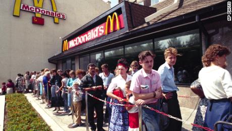 ロシア人は1990年にモスクワにあるマクドナルドのファーストフードレストランの外で並んで待っています。 