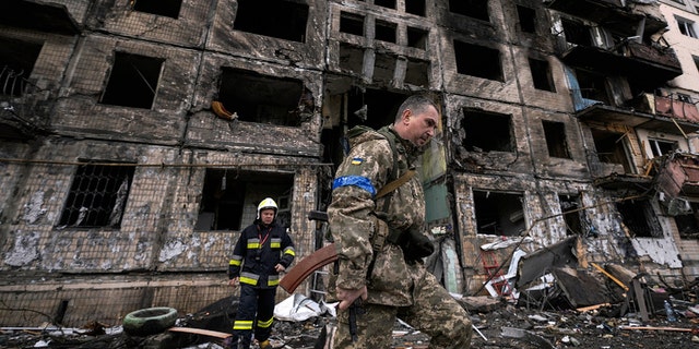 ウクライナの兵士と消防士が、2022年3月14日月曜日、ウクライナのキーウで爆弾攻撃を受けた後、破壊された建物を捜索します（AP Photo / Vadim Ghirda）