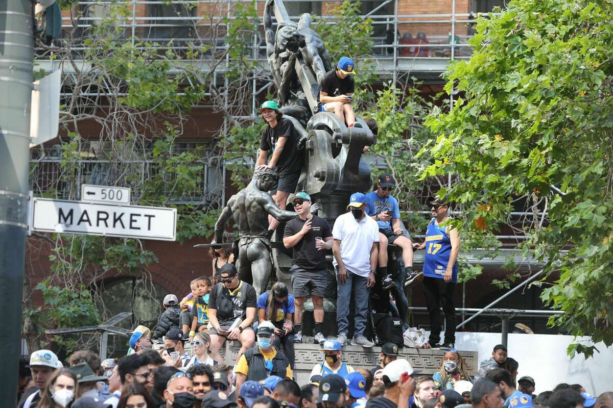 ゴールデンステートウォリアーズのファンは、2022年6月20日にサンフランシスコで開催されたチームの勝利パレードに先立ってマーケットストリートに並んでいます。