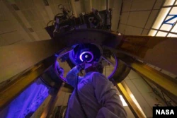 DART チームのメンバーは、DART 宇宙船の唯一の機器であるディディモス偵察カメラと小惑星航法カメラ (DRACO) を 2021 年 6 月に宇宙船に取り付けて検査します (画像のクレジット: NASA/Johns Hopkins APL/Ed Whitman)