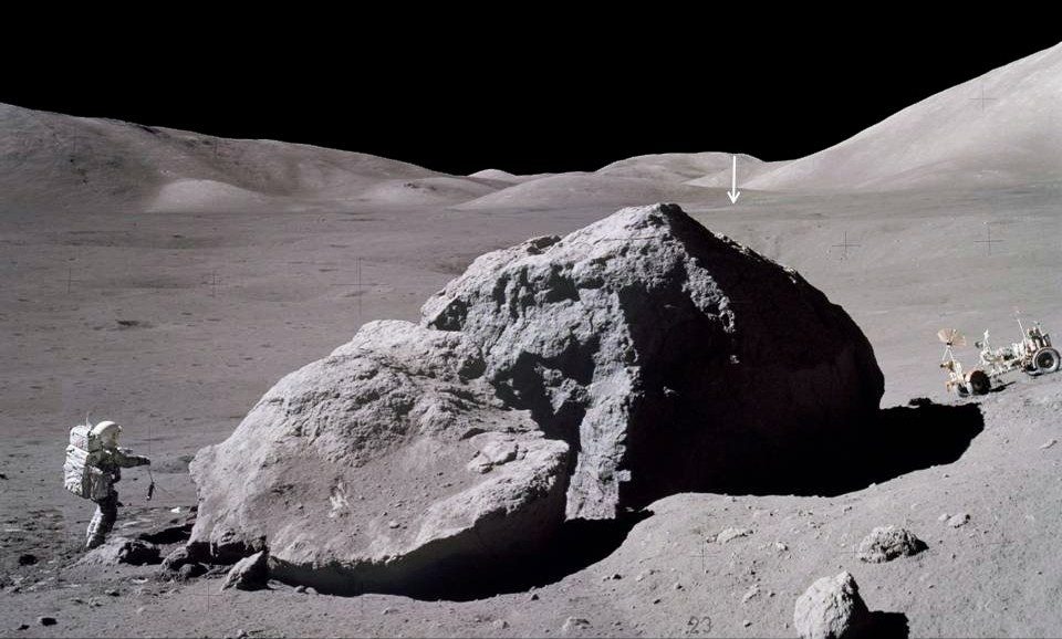 月で最長のプログラムであるアポロ 17 号の表面時間は、3 日 2 時間 59 分でした。 この画像は、アポロ 17 号宇宙船のジャック シュミットが、巨大な岩の東側を観察してサンプリングした後、月着陸船に向かってサソリを運んでいるところを示しています。 遠くにある垂直の矢印は、約 2 マイル (3.1 km) 離れた月着陸船チャレンジャーを指しています。