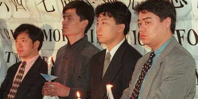 中国の学生指導者たちは、天安門事件の7周年を記念して、6月3日にワシントンの中国大使館の外でろうそくの集会を開きました。 天安門での抗議行動を主導した学生たちは後に中国から逃亡した. 写真左から右へ: Liu Gang, Zhou Fengsu, Chen Tong, Weer Kaishi. 